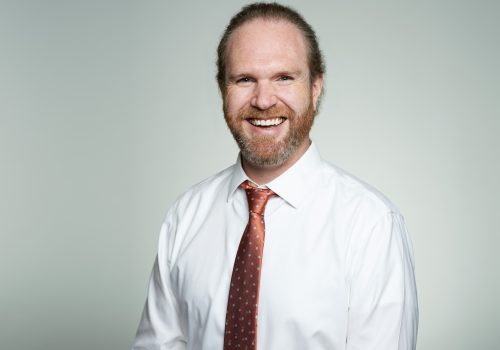 A head and shoulder shot of a smiling man with a beard.
